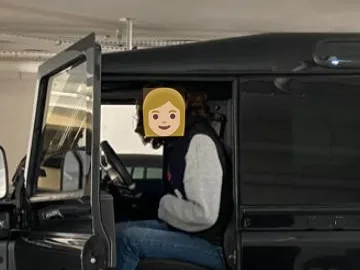 Portière du Defender ouverte : la personne assise au volant a un emoji sosie aux cheveux blonds à la place du visage.