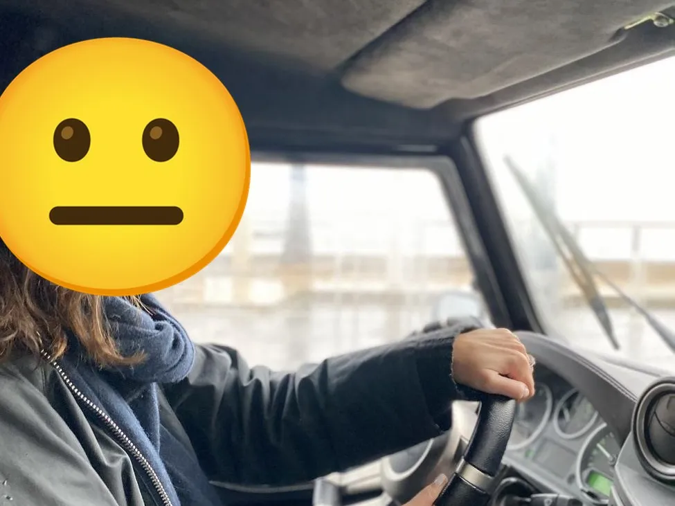 Une personne au volant du Defender, le visage remplacé par un emoji sosie aux cheveux bouclés.